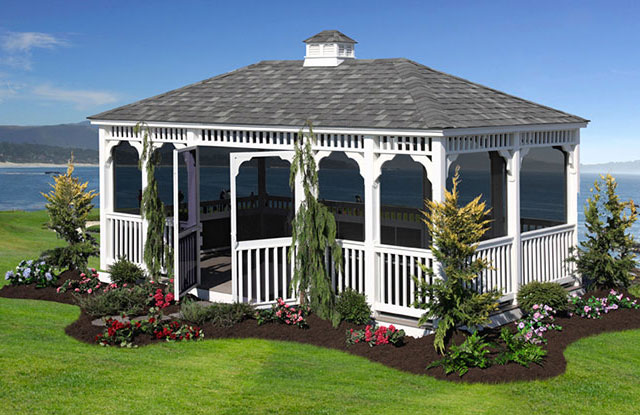 white amish built gazebo sitting on green grass beneath blue sky