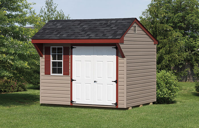 mini quaker series shed with tan siding red trim and white doors
