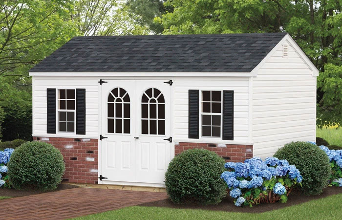 storage shed with white siding and decorative stone panel