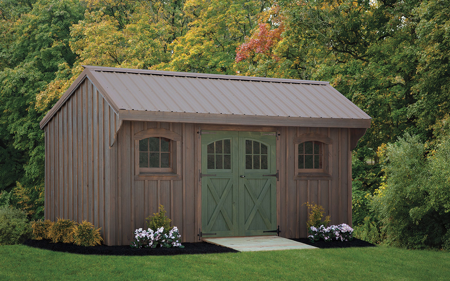 quaker series shed with weathered gray siding and green doors