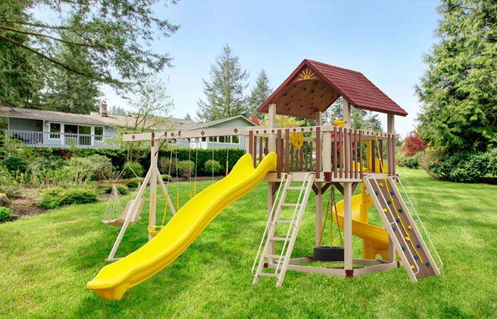 custom swing set with small climbing wall and multiple slides