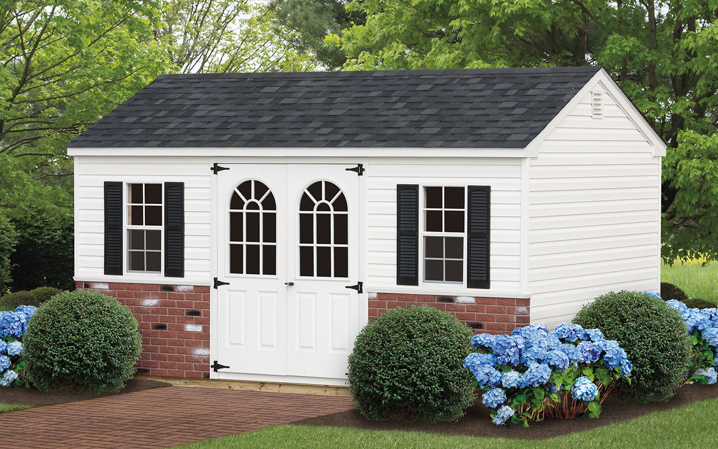 white a frame storage shed with brick panels